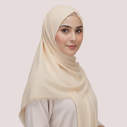 Woman wearing a beige hijab against a light pink background