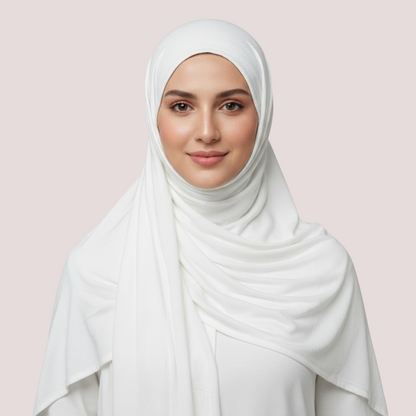 Woman wearing a white hijab against a light pink background